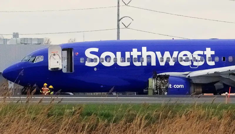 Emergency personnel monitor the damaged engine of Southwest Airlines Flight 1380, which diverted to the Philadelphia International Airport this morning, in Philadelphia, Pennsylvania