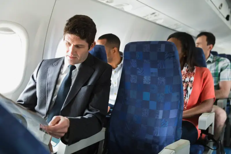 Businessman reading newspaper in airplane