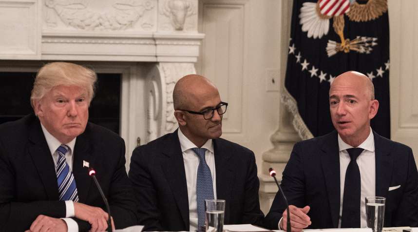 President Donald Trump (L) and Microsoft CEO Satya Nadella (C) listen to Amazon CEO Jeff Bezos (R) during an American Technology Council roundtable at the White House in Washington, DC, on June 19, 2017.
