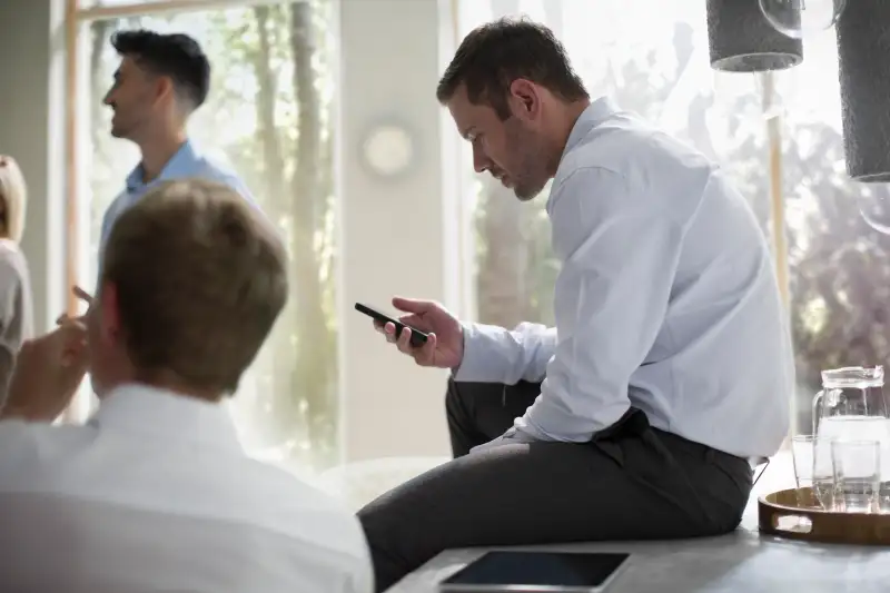 Businessman using smart phone in a meeting