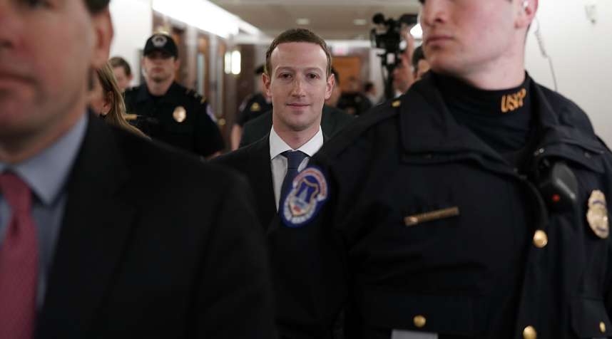 Facebook CEO Mark Zuckerberg (C) is escorted by U.S. Capitol Police as he walks in a hallway prior to a meeting with U.S. Sen. John Thune (R-SD), April 9, 2018, in Washington, DC.