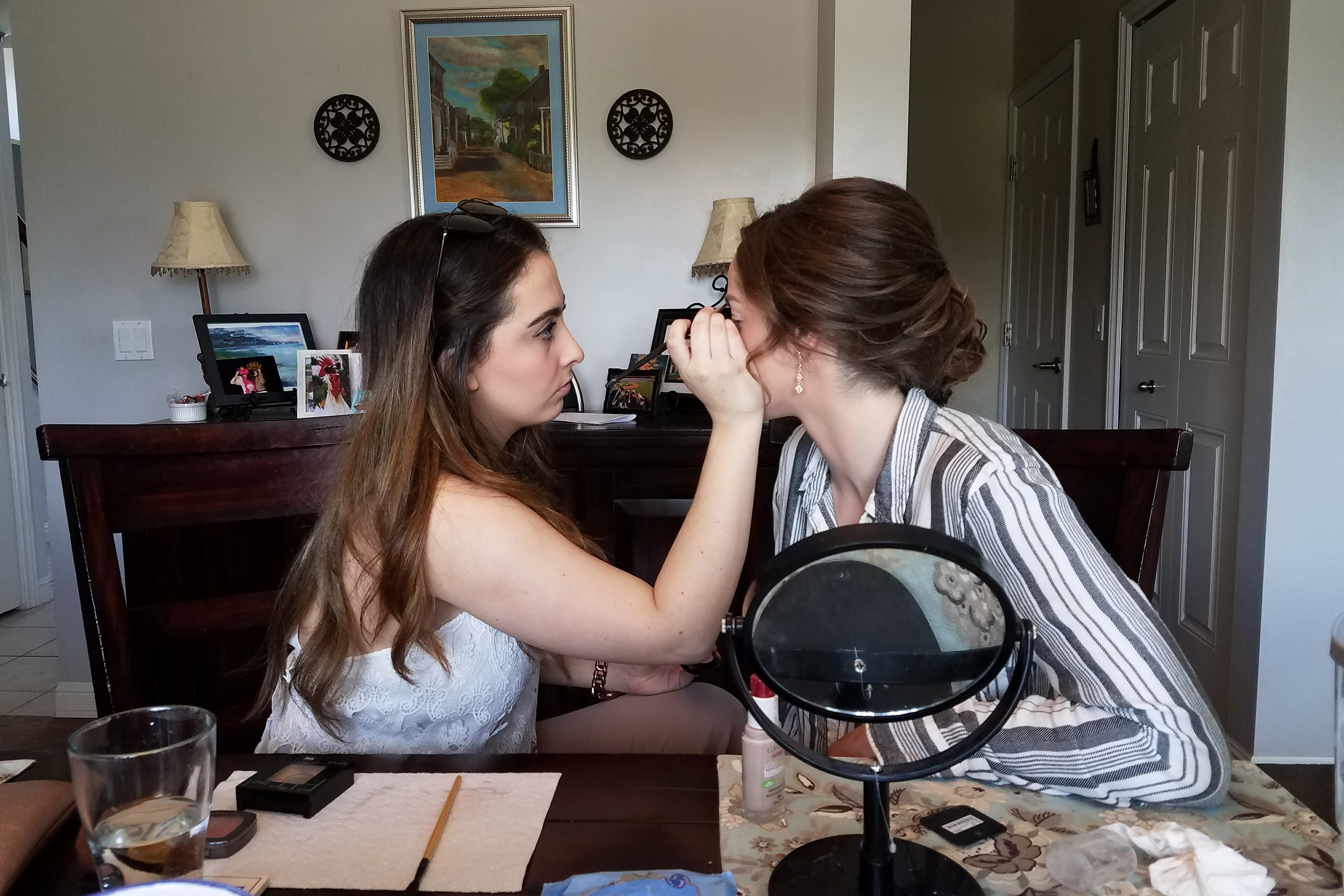 Katherine Crapps gets her makeup done by her friend, Giovanna Scappaticci, for her prom in 2017.