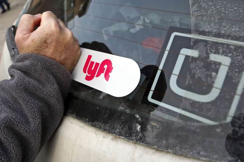 This is a Lyft logo being installed on a Lyft driver's car who also drives for Uber on in Pittsburgh, January 31, 2018.