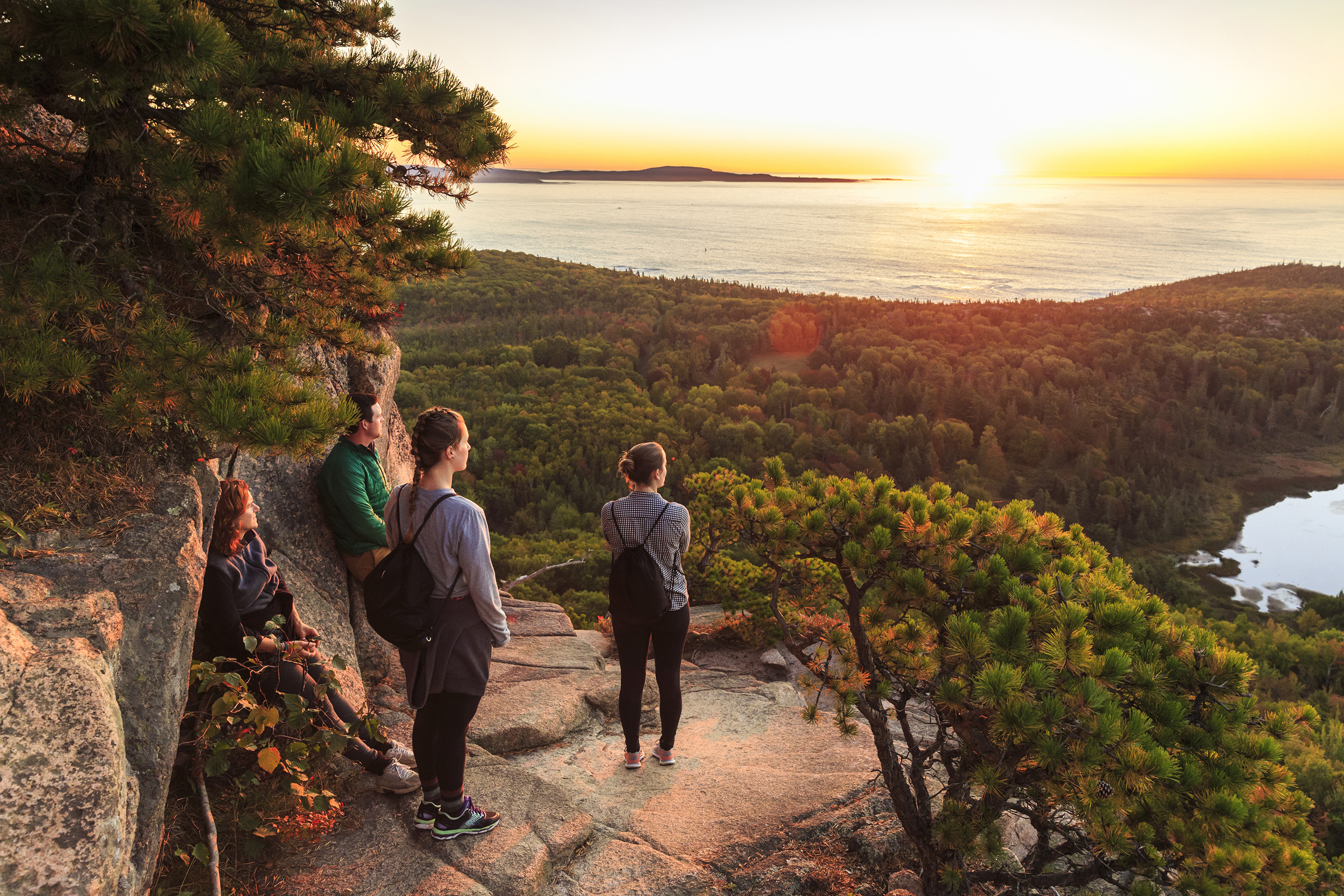 People watching sunrise on Beehive in fall Acadia National Park, Maine