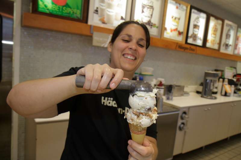 A woman scooping out Haagen Dazs ice cream.