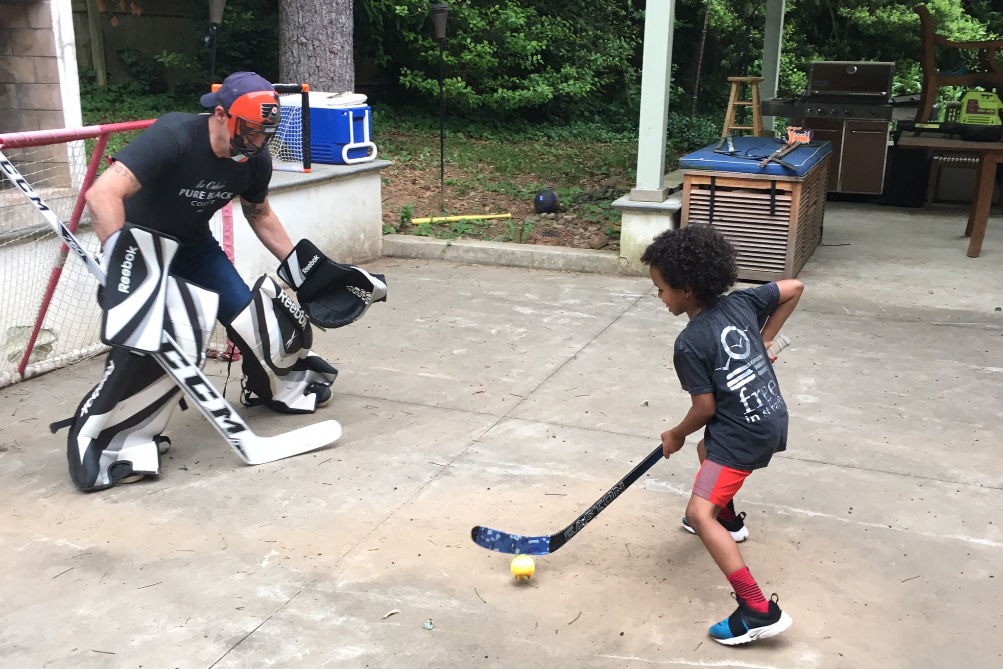 Todd Carmichael playing street hockey with his son, Ben