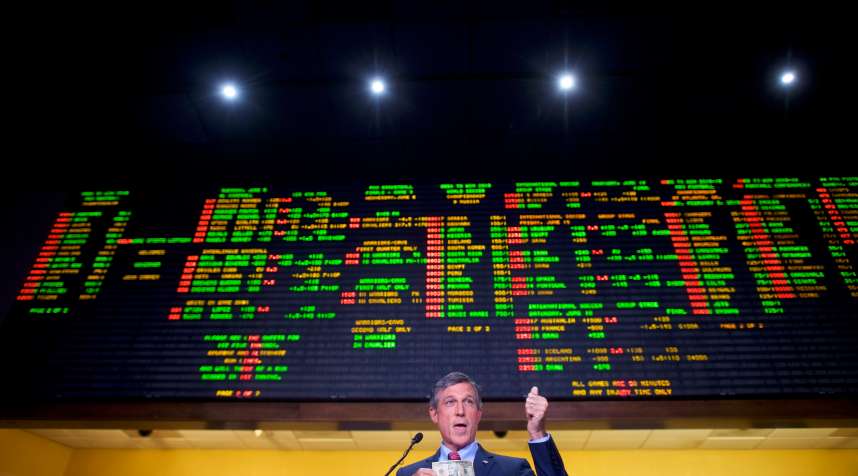 Delaware Governor John Carney holds a $10 bill he used to place the first bet at Dover Downs Casino on June 5, 2018.