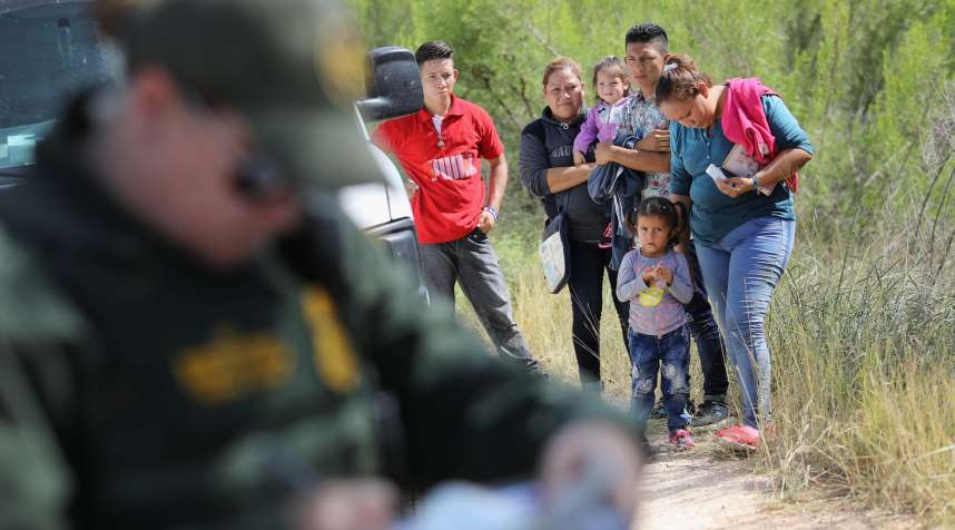 Central American asylum seekers wait as U.S. Border Patrol agents take groups of them into custody on June 12, 2018 near McAllen, Texas.