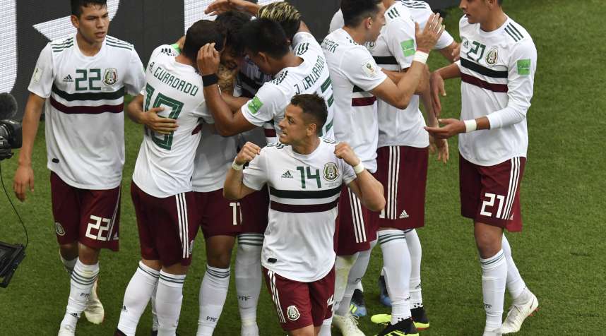 Mexico's forward Carlos Vela (C) with teammates after scoring a penalty in a 2018 World Cup match against South Korea.