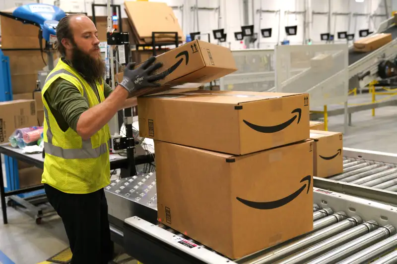 A worker moves packed boxes at the Amazon fullfillment center May 3, 2018 in Aurora, Colorado.