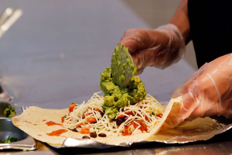 An employee prepares a Chipotle Mexican Grill burrito at the Sunset and Vine store in Hollywood, Calif.