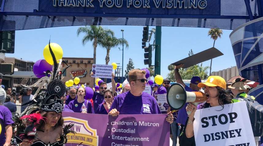 Disney workers, along with union employees, enter Disneyland as they protest for higher wages at Disneyland Resort in Anaheim, CA, on Thursday, June 14, 2018.