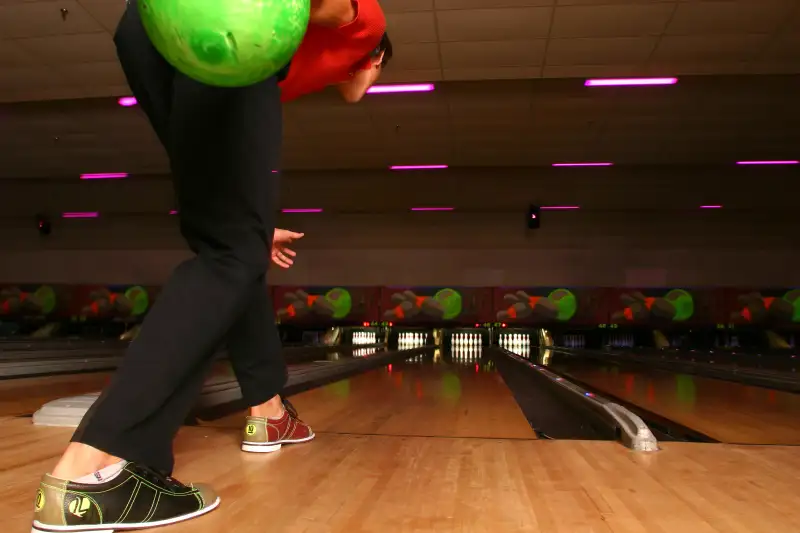 Young man preparing to bowl, rear view