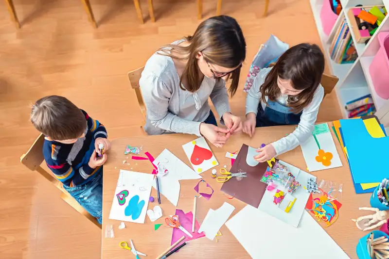 Preschool teacher with kids having creative activities