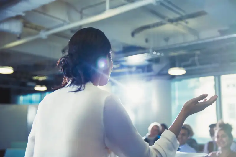 Businesswoman gesturing, leading conference presentation