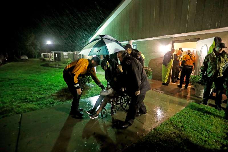 Members of the Nebraska Task Force 1 urban search and rescue team help load an elderly resident onto a bus as they evacuate an assisted living facility to a church as a precaution against potential flooding the city could see from tropical storm Florence in Fayetteville, North Carolina on Sept. 15, 2018.