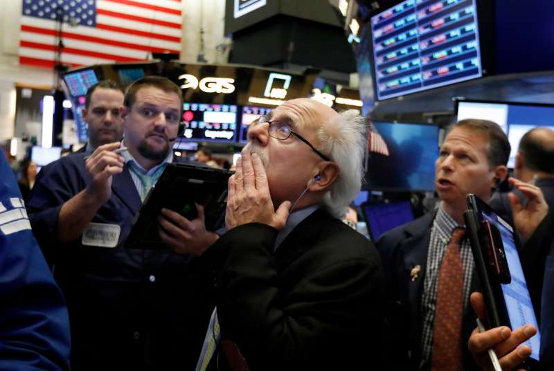 Peter Tuchman, center, works with fellow traders on the floor of the New York Stock Exchange, . Stocks are opening broadly lower on Wall Street, a day after a massive surge, as a number of big companies reported disappointing results Financial Markets Wall Street, New York, October 26, 2018.