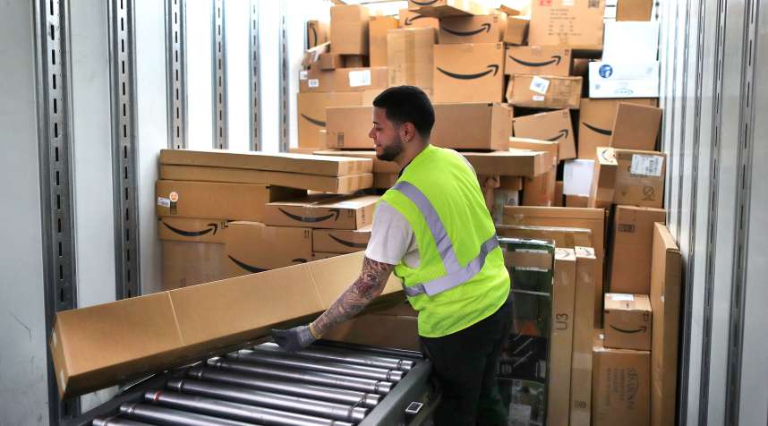 A worker loads customer orders into a waiting tractor-trailer inside the million-square foot Amazon distribution warehouse