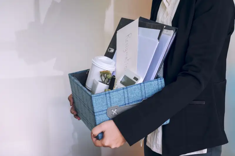 Midsection Of Employee Leaving The Office While Carrying The Box