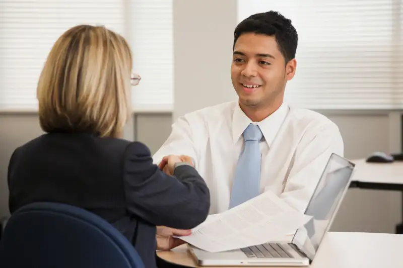 Businesswoman shaking hands with co-worker