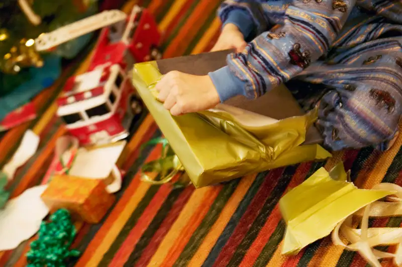 Young boy unwrapping Christmas present