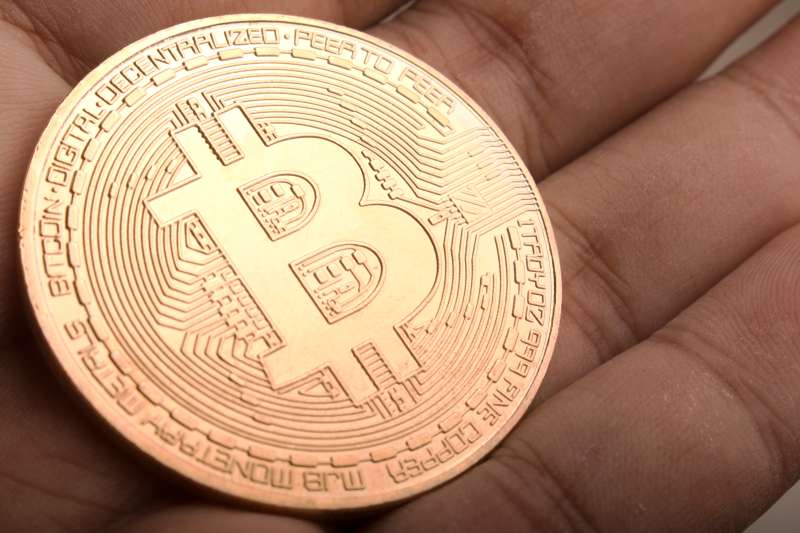 Close-Up Of Hand Holding Bitcoin