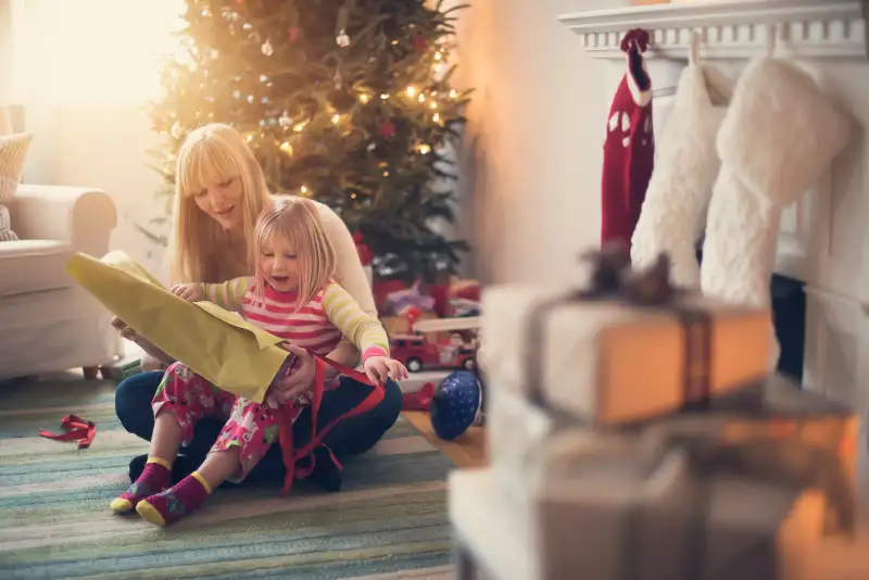 USA, New Jersey, Mother and daughter (4-5) opening christmas presents