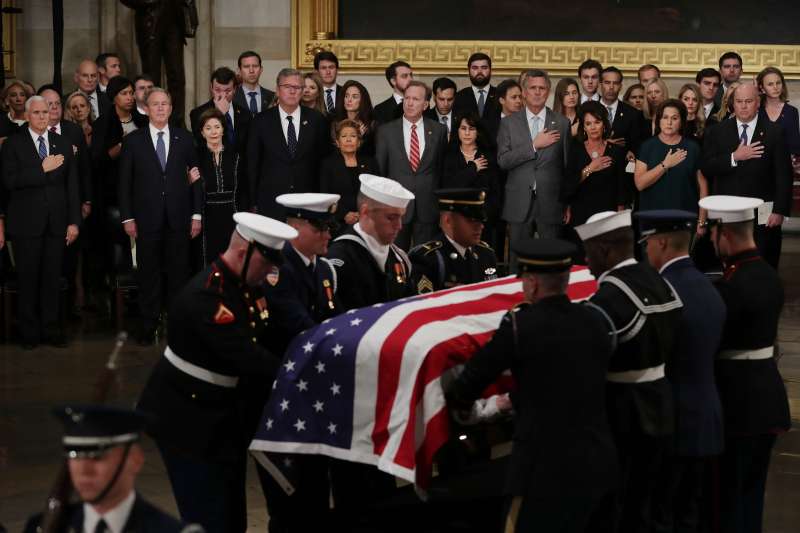 The family of former U.S. President George H.W. Bush stand as his flag-draped casket is carried into the U.S. Capitol Rotunda on December 03, 2018 in Washington, D.C.