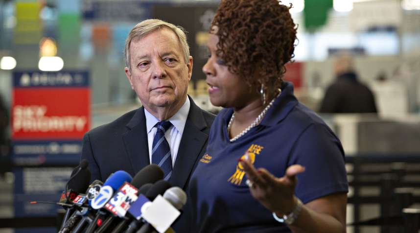 Janis Casey, women's coordinator for American Federation of Government Employees (AFGE), speaks while Senate Minority Whip Dick Durbin, a Democrat from Illinois, left, listens during a press conference on how the partial government shutdown is affecting Transportation Security Administration (TSA) employees at O'Hare International Airport (ORD) in Chicago