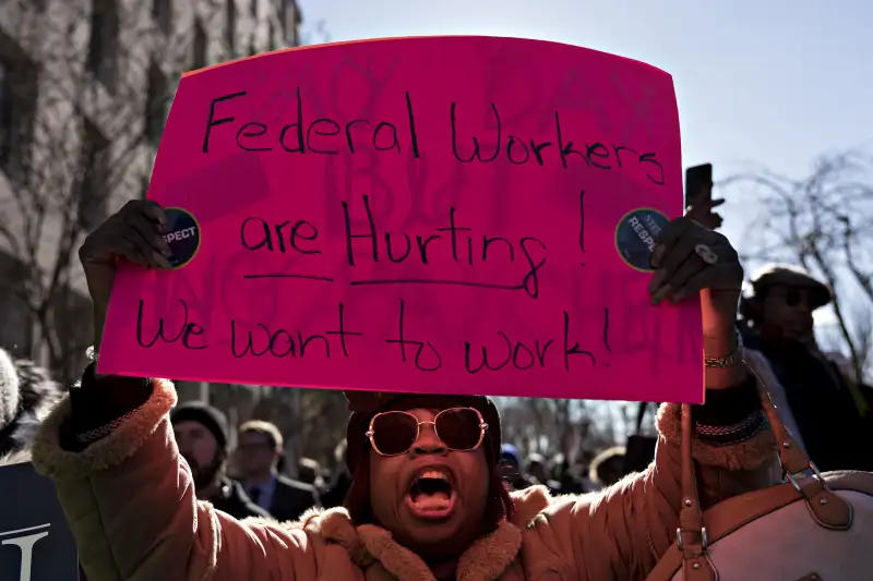 A furloughed federal employee holds a sign during a rally to end the partial government shutdown outside the American Federation of Labor & Congress of Industrial Organizations (AFL-CIO) headquarters in Washington, D.C., U.S., on Thursday, Jan. 10, 2019.