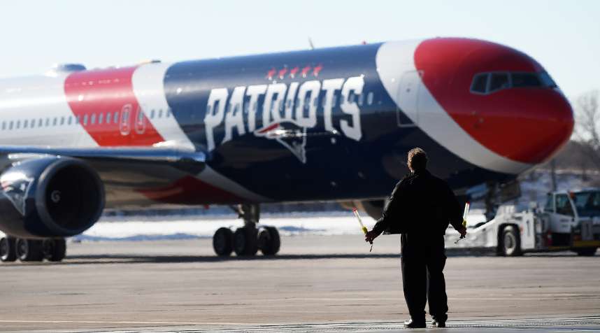 A member of the ground crew guides the team plane of the New England Patriots as it arrives for Super Bowl LII on January 29, 2018 at the Minneapolis-St. Paul International Airport in Minneapolis, MN.
