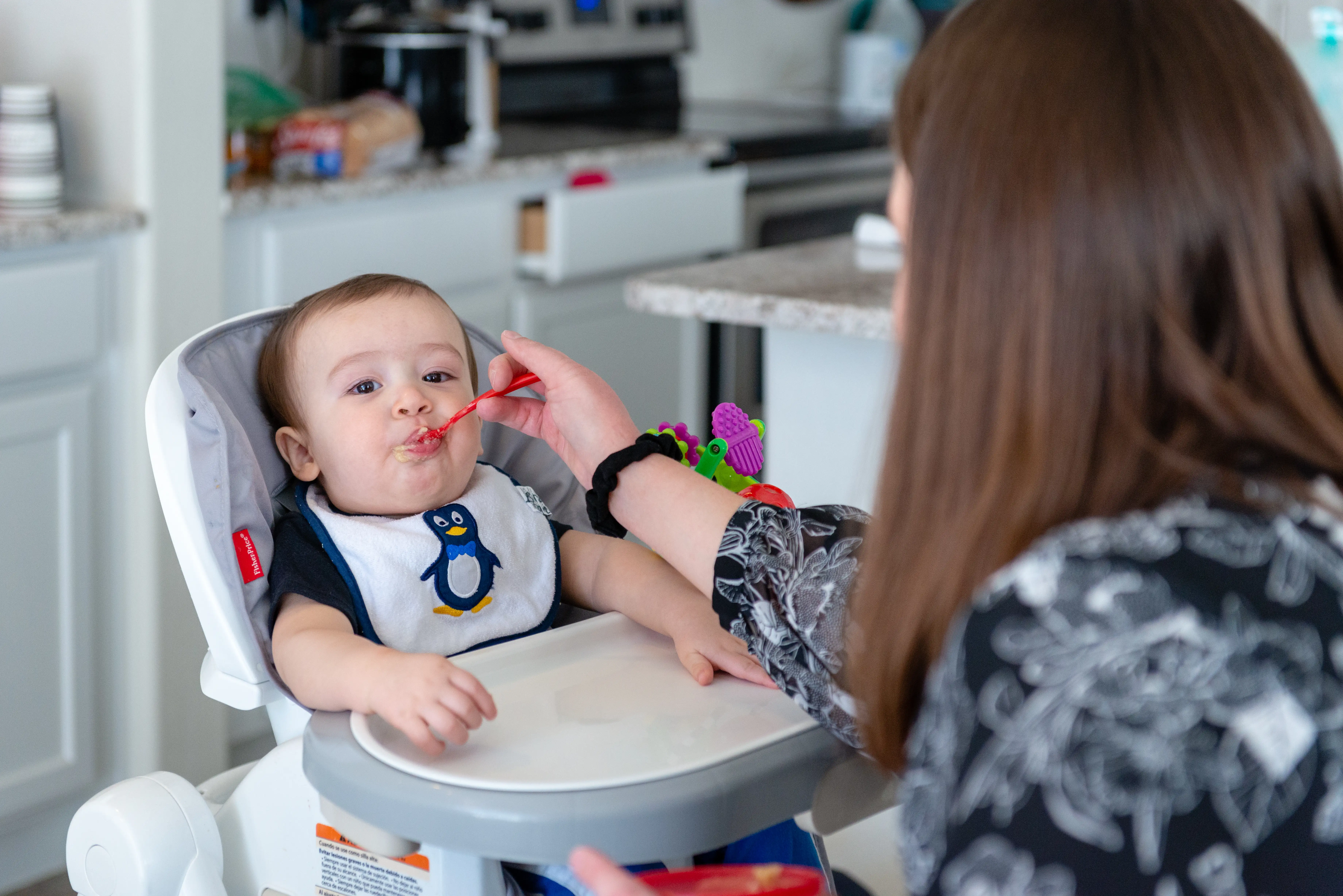 Tiffany Cano feeds 10-month-old Brody on Oct. 20, 2018. She works 40 hours a week at a local bank as a compliance officer, commuting more than 90 minutes each way, while Brody attends a local day care center. Because her husband works so much, she says, she often feels as if sheâs raising their son alone.