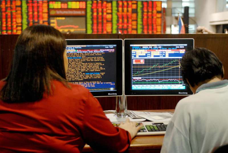 Traders monitor stocks price index at th