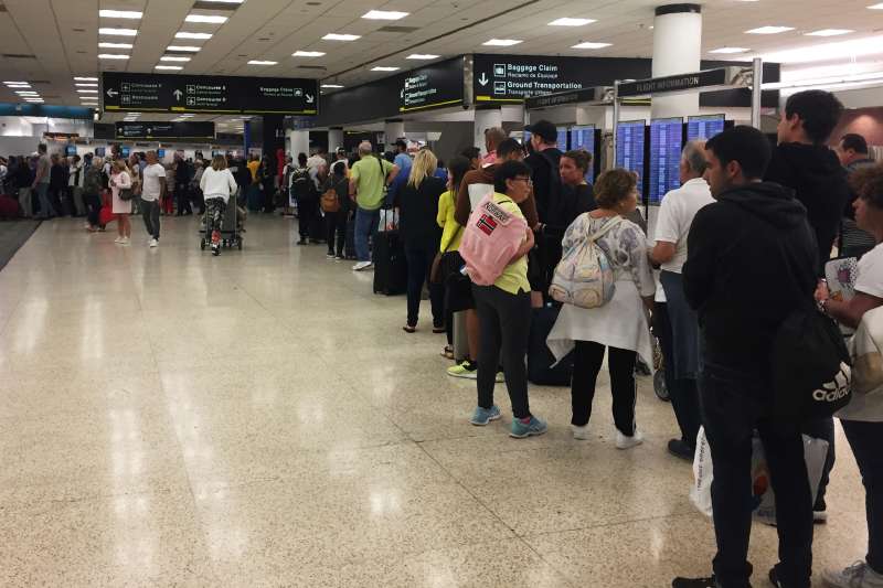 Passengers flying from Miami International Airport wait in line to enter the checkpoint at Concourse F, where some of the flights of a closed terminal were diverted, on January 13, 2019.