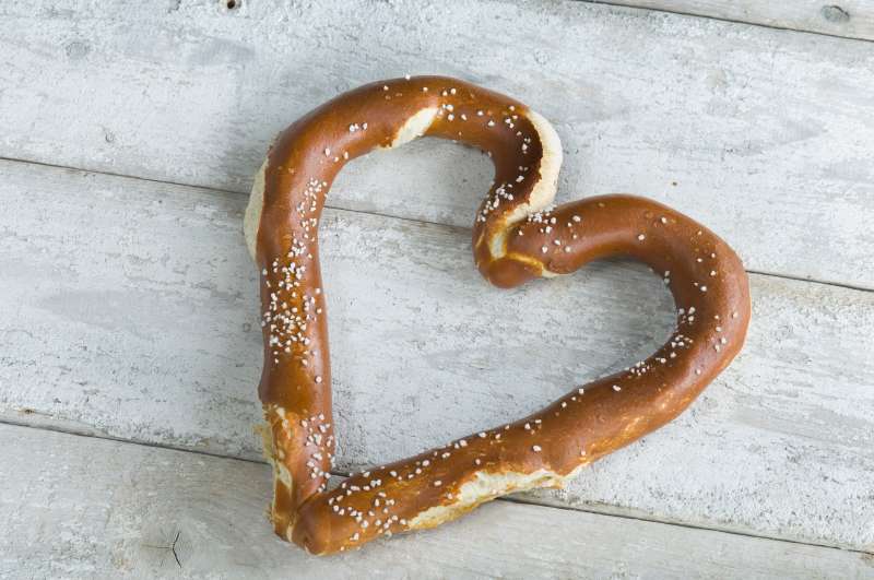 Heart shaped pretzel on white wood