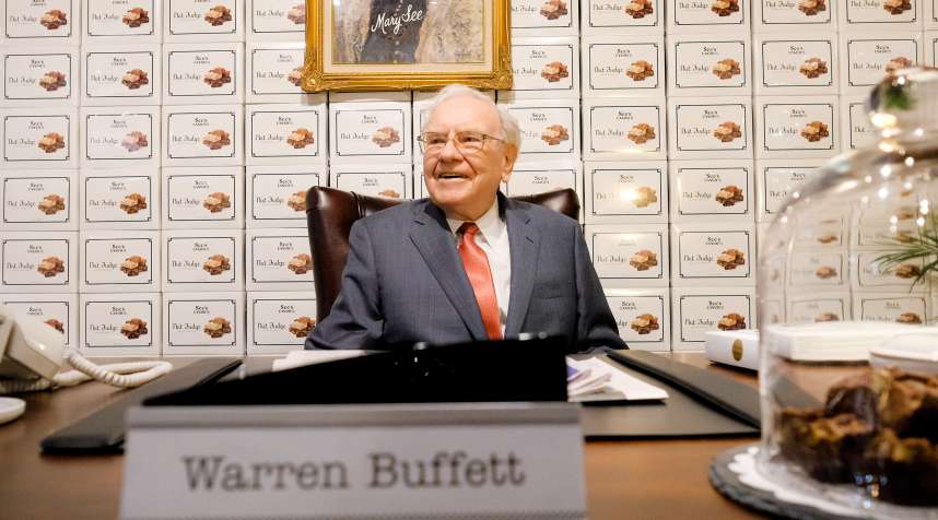 Warren Buffett sits behind a desk under a portrait of founder Mary See at the See's Candies booth during a part of the Berkshire Hathaway Annual Shareholders Meeting on April 29, 2016 in Omaha Neb.