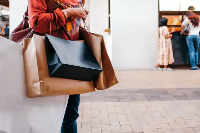 Midsection Of Woman Holding Shopping Bags