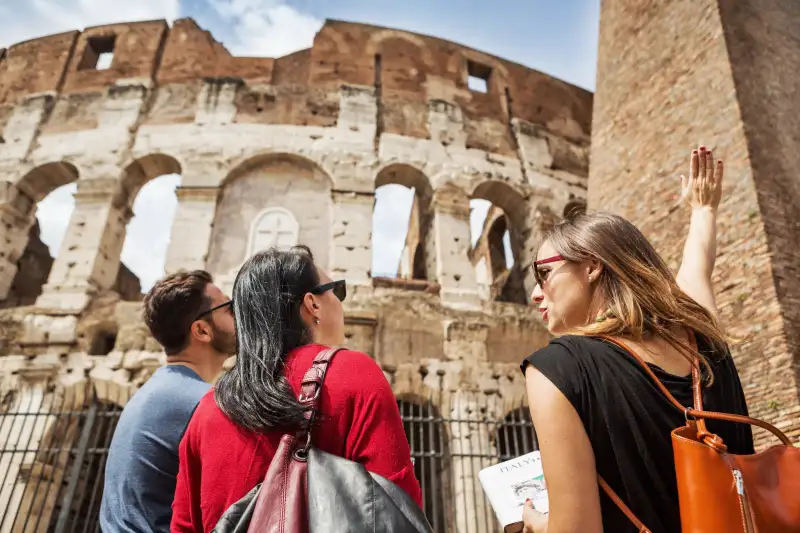 Guide explaining to tourists the Coliseum of Rome