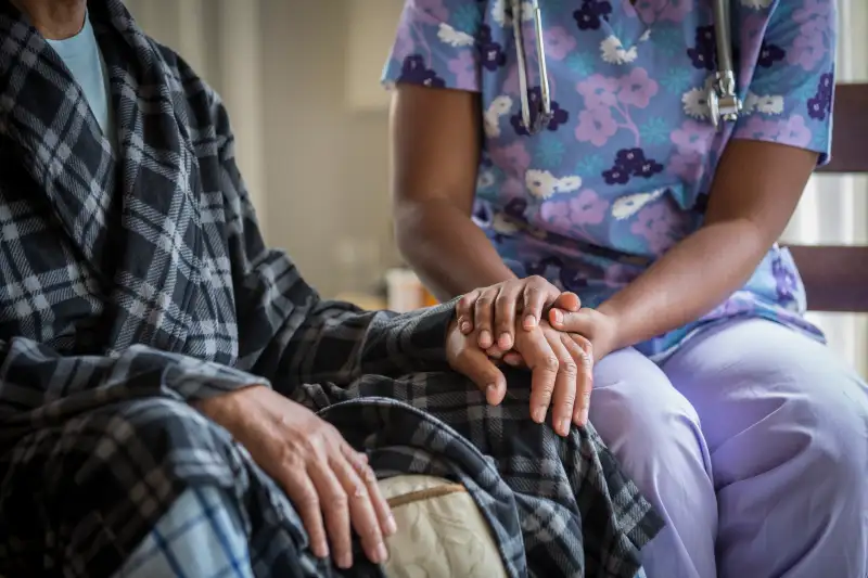 nurse holding patient's hand