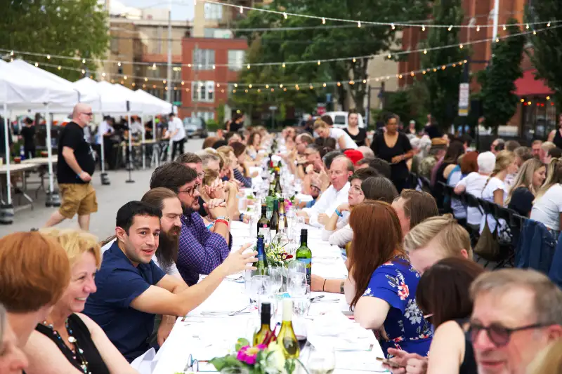 People eating at long table outdoors in Iowa City, Iowa