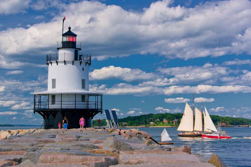 light house and sail boat off the coast of Portland, Maine