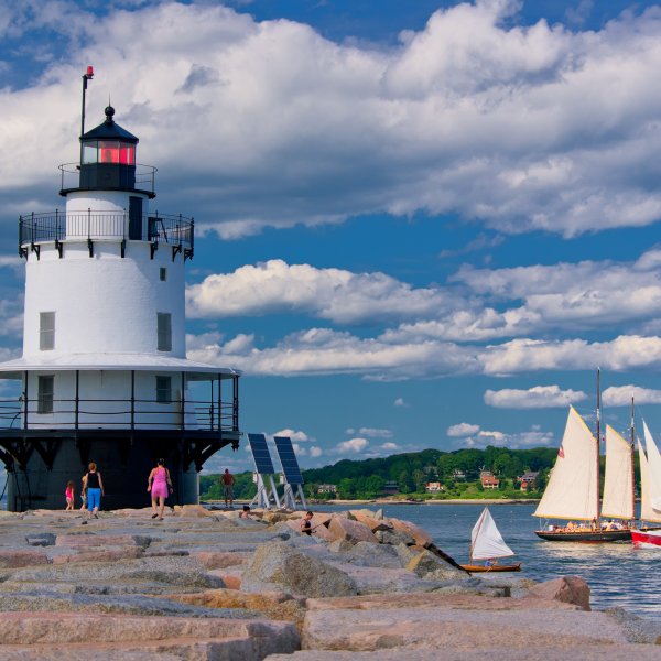 light house and sail boat off the coast of Portland, Maine