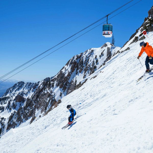 Parent and child skiing down a mountain in Layton, Utah