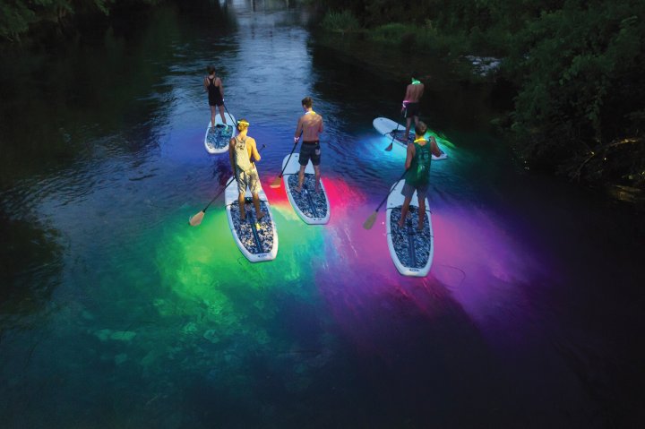 Three people on paddle boards in San Marcos, Texas