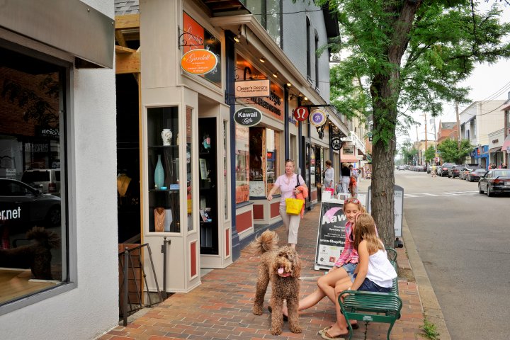 girls sitting with dog outside of a shop in Shadyside neighborhood in Pittsburgh, Pennsylvania