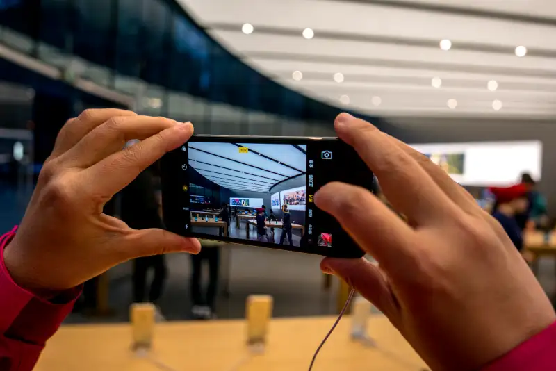 A customer is trying an iPhone 7 in the apple shop.  On the