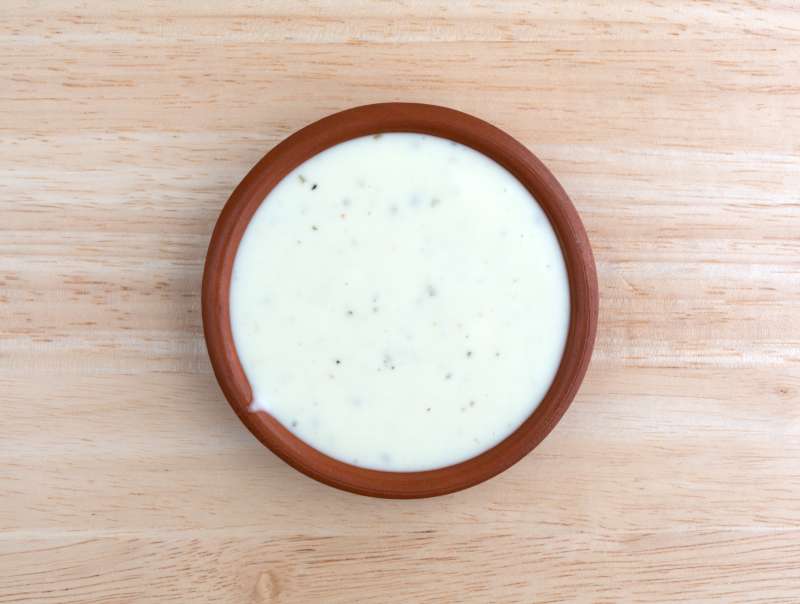 Bowl of ranch dressing on a wood table top view