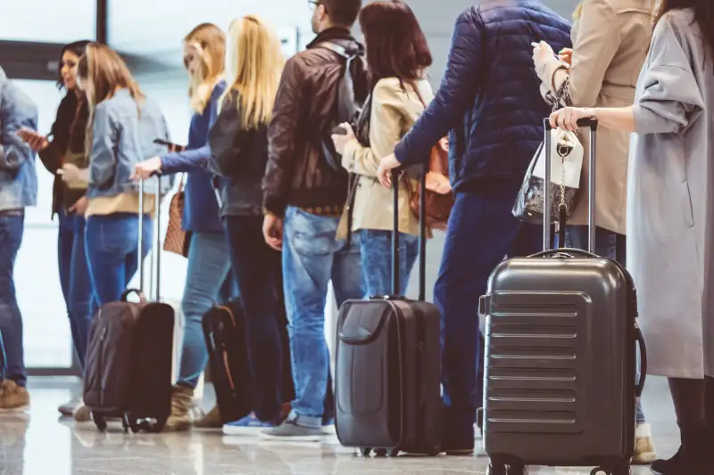 Group of people standing in queue at boarding gate