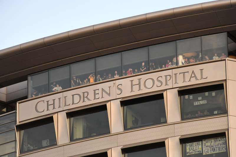Patients and their families watch from the top floor of the Iowa Children's Hospital during a University of Iowa college football game.