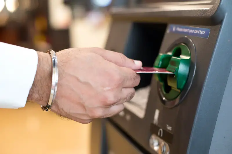 Hand inserting ATM credit card